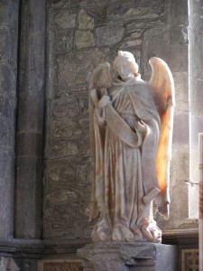 photo of a statue of an angel near a tomb in St. David's Cathedral, Wales, UK