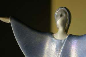 photo of ceramic figure with arms raised in praise