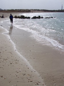 picture of man walking along a beach