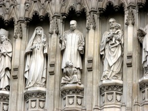 photo of statues of modern saints on pillars